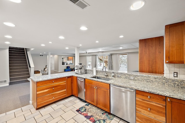 kitchen with dishwasher, sink, light stone counters, kitchen peninsula, and decorative backsplash