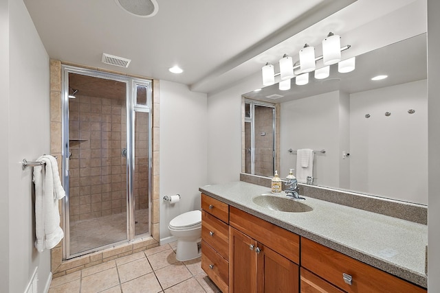 bathroom with tile patterned floors, a shower with door, vanity, and toilet