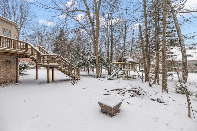 yard covered in snow featuring a playground