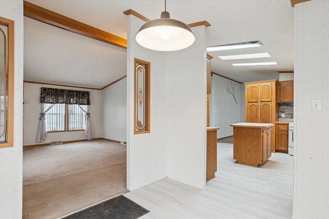 hall with light hardwood / wood-style floors, a textured ceiling, and ornamental molding