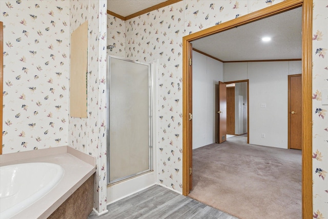 bathroom featuring a textured ceiling, wood-type flooring, crown molding, and independent shower and bath