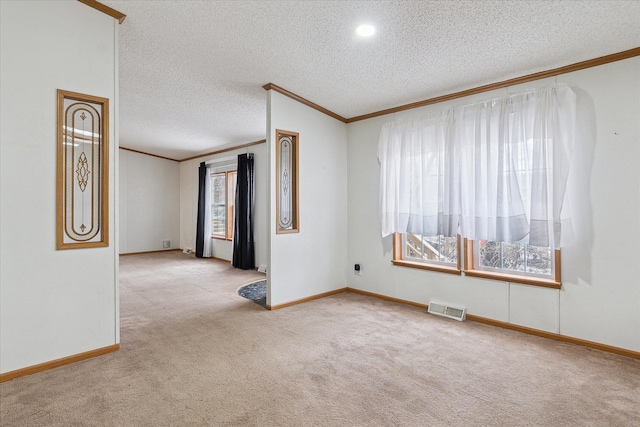 carpeted spare room featuring a textured ceiling, crown molding, and a wealth of natural light