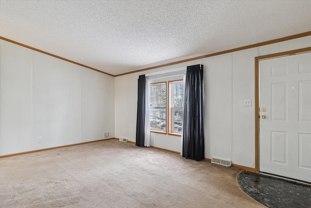 unfurnished room with a textured ceiling, carpet floors, and crown molding