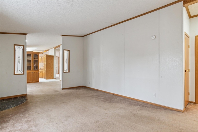 carpeted spare room featuring a textured ceiling and ornamental molding