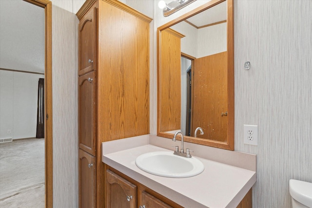 bathroom featuring vanity, toilet, and ornamental molding