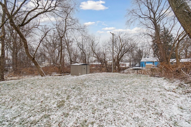 snowy yard featuring a storage shed