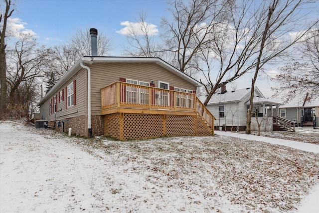 snow covered property with a deck and cooling unit