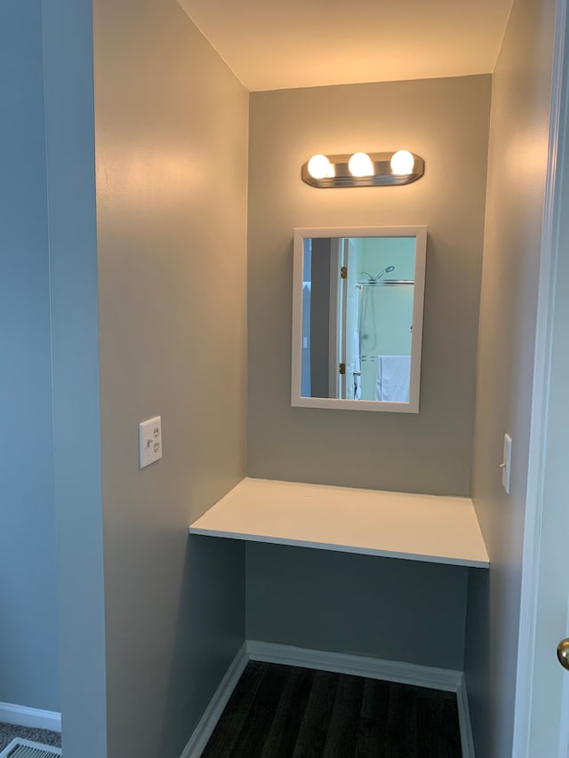 bathroom with wood finished floors and baseboards