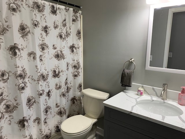 bathroom with toilet, curtained shower, and vanity