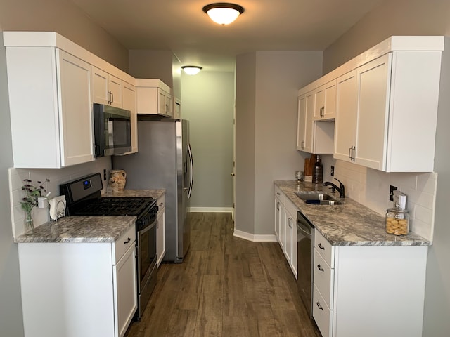 kitchen with a sink, decorative backsplash, stainless steel appliances, white cabinetry, and dark wood-style flooring