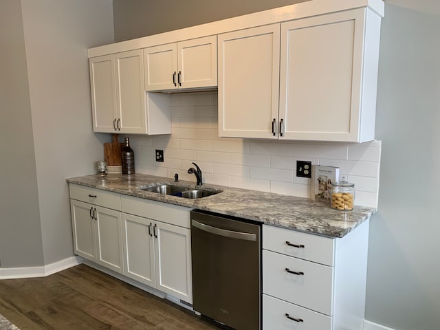 kitchen with stainless steel dishwasher, light stone counters, tasteful backsplash, and a sink