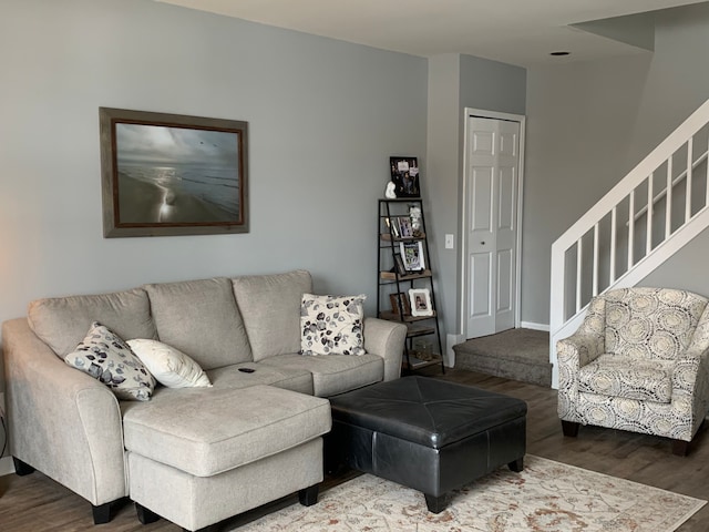 living area featuring stairs, wood finished floors, and baseboards