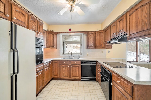 kitchen with sink, black appliances, kitchen peninsula, and a textured ceiling