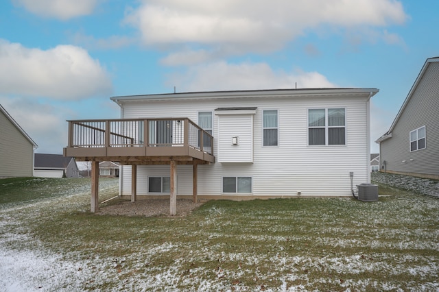 snow covered house with a lawn, cooling unit, and a deck