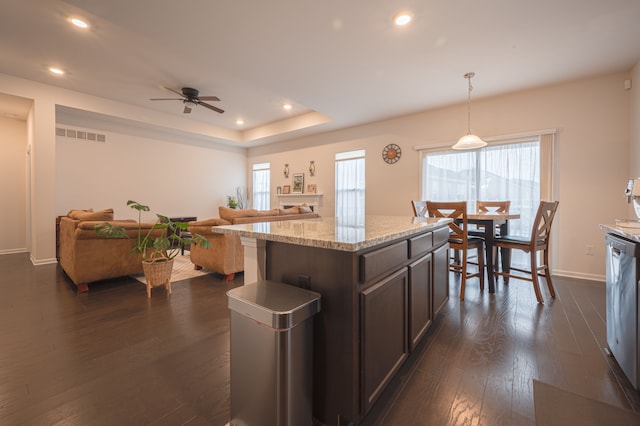 kitchen with decorative light fixtures, dark hardwood / wood-style flooring, dark brown cabinetry, and a wealth of natural light