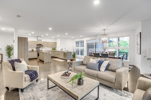 living room with a notable chandelier and light hardwood / wood-style flooring