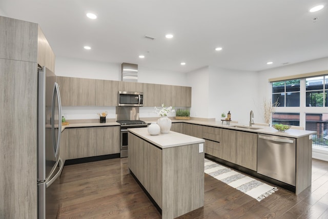 kitchen with appliances with stainless steel finishes, a kitchen island, light brown cabinetry, and sink