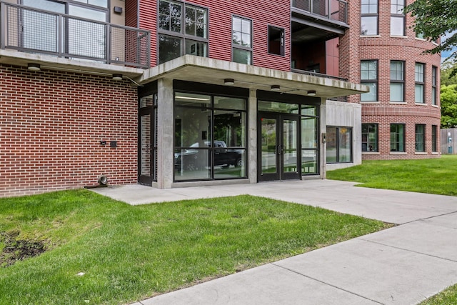 property entrance with a lawn