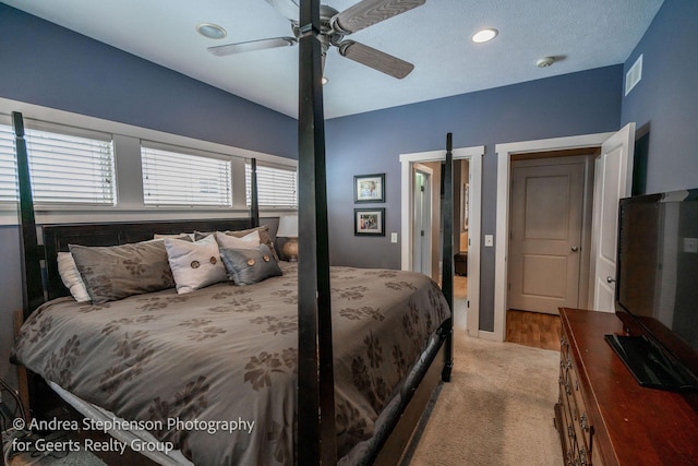 bedroom featuring ceiling fan, visible vents, and light colored carpet