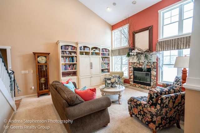 living area featuring high vaulted ceiling, light carpet, a fireplace, and baseboards