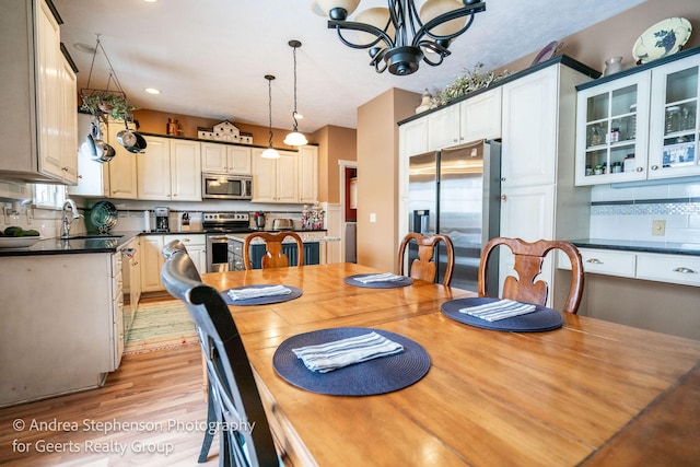 dining room with recessed lighting, light wood-type flooring, and a notable chandelier