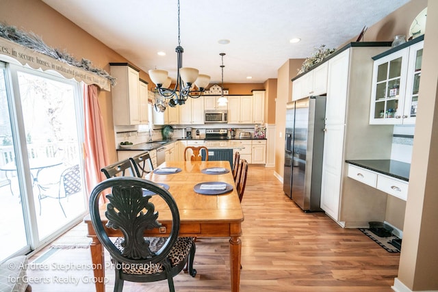 dining area with a chandelier, recessed lighting, baseboards, and light wood finished floors