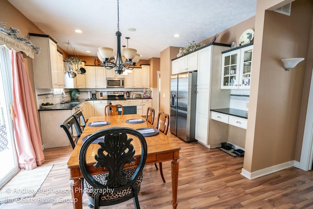 dining room with baseboards, visible vents, wood finished floors, a chandelier, and recessed lighting