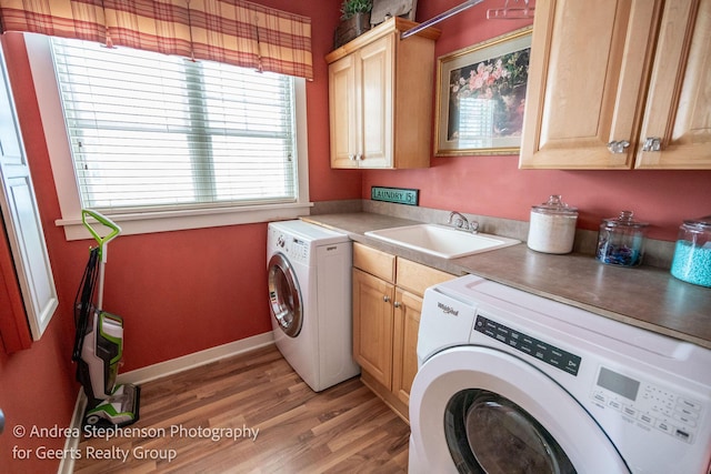 laundry area featuring separate washer and dryer, a sink, baseboards, cabinet space, and dark wood finished floors