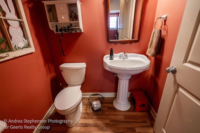 bathroom featuring baseboards, toilet, and wood finished floors