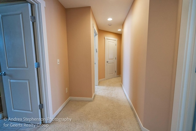 hall featuring baseboards, light colored carpet, and recessed lighting