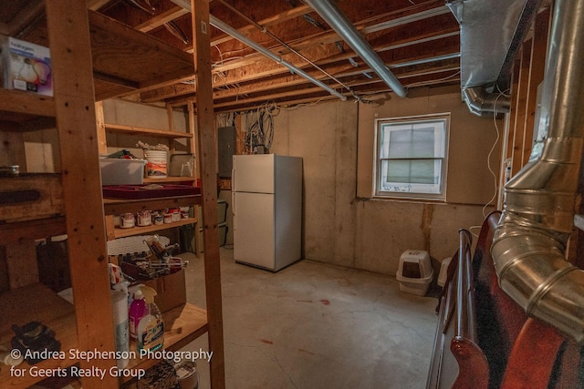 basement featuring freestanding refrigerator and electric panel