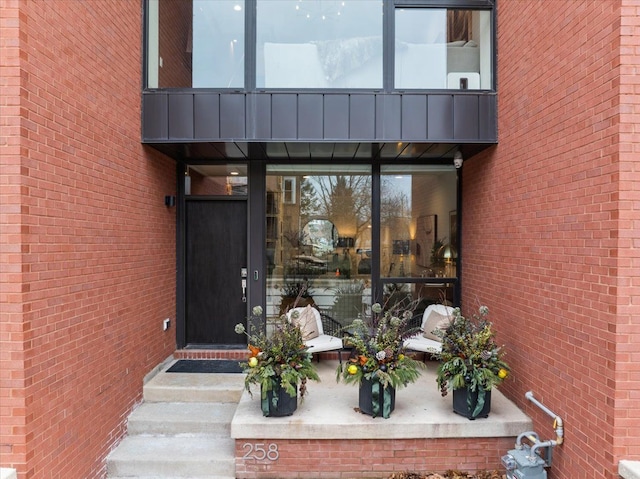 doorway to property with brick siding