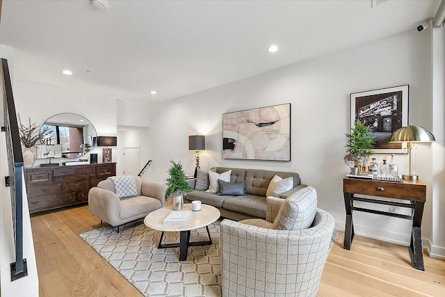 living area featuring baseboards, light wood-style flooring, and recessed lighting
