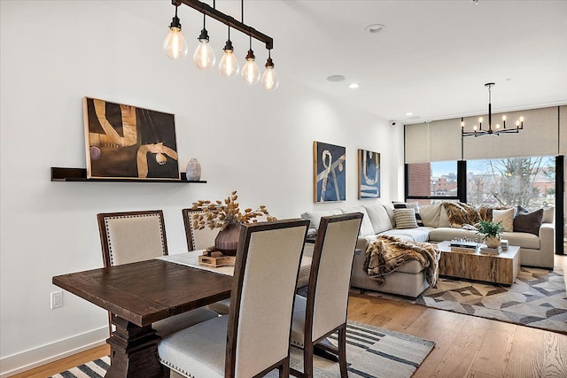dining room with baseboards, recessed lighting, hardwood / wood-style flooring, and a chandelier