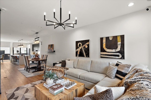 living room with baseboards, wood finished floors, a chandelier, and recessed lighting