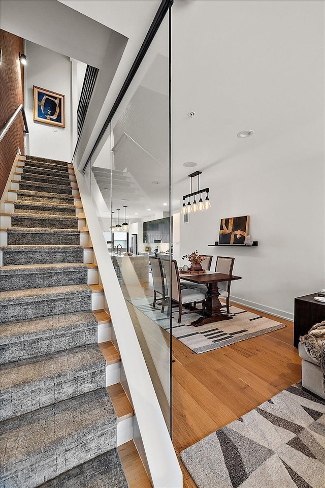 stairway with baseboards and wood finished floors