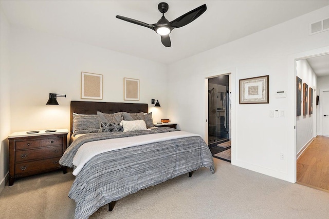 carpeted bedroom with connected bathroom, baseboards, visible vents, and ceiling fan