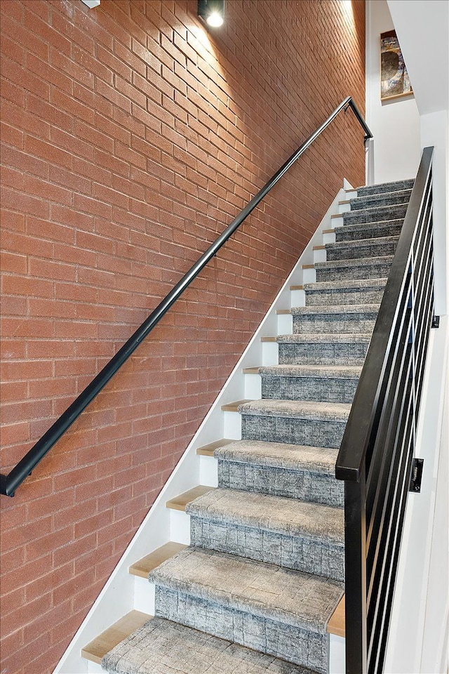 stairs with a high ceiling and brick wall