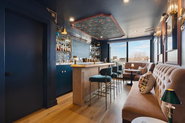 bar featuring recessed lighting, wet bar, and light wood-type flooring