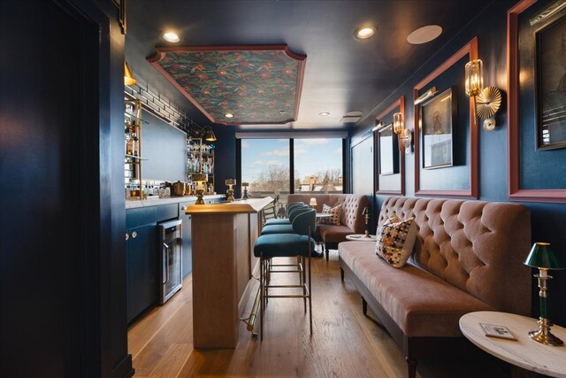 interior space featuring wet bar, wine cooler, light wood-style flooring, and recessed lighting