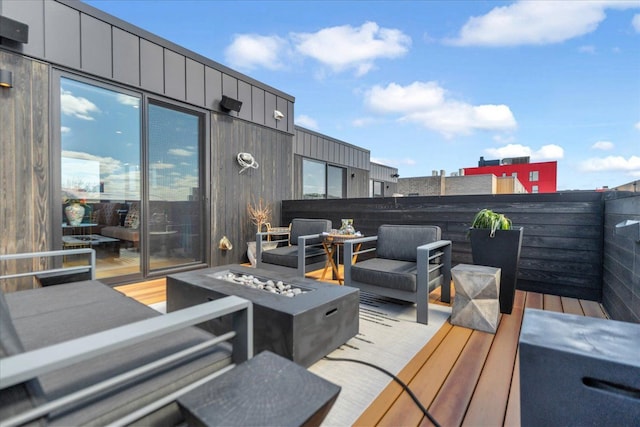 wooden deck with an outdoor living space with a fire pit
