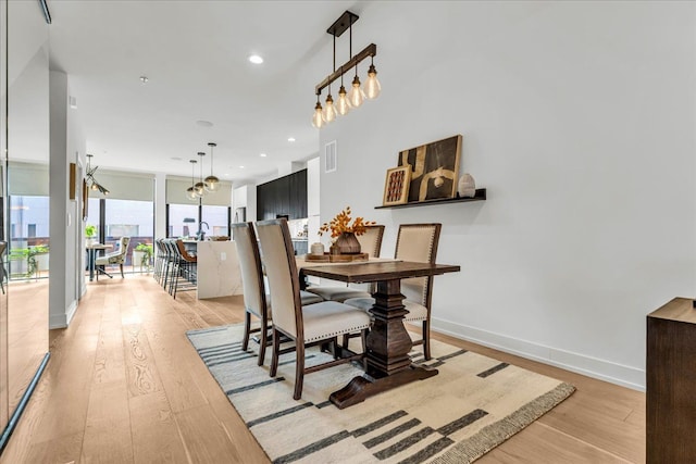 dining room featuring baseboards, light wood-type flooring, visible vents, and recessed lighting