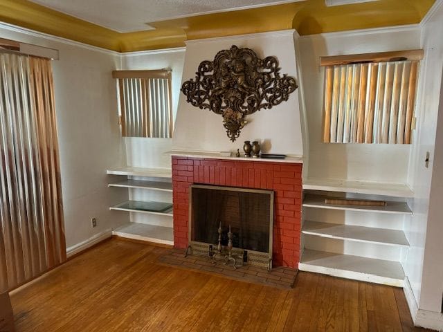 unfurnished living room featuring wood-type flooring and a brick fireplace