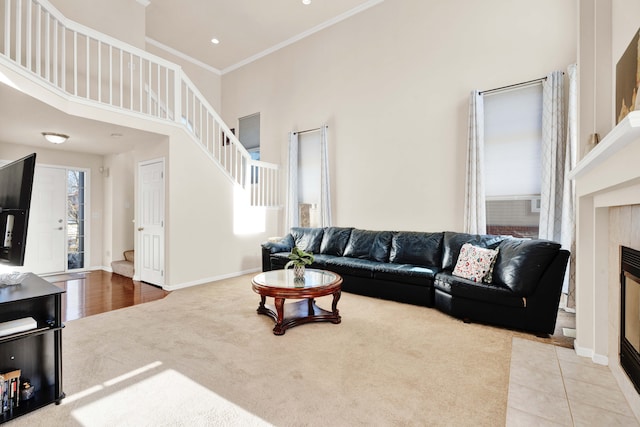 living room featuring ornamental molding, light colored carpet, a fireplace, and a high ceiling