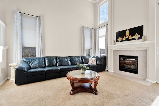 living room with a towering ceiling, a fireplace, and carpet flooring