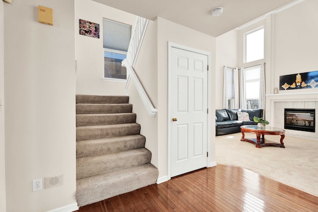 stairs featuring a fireplace and hardwood / wood-style floors