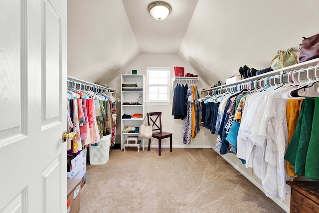 walk in closet with vaulted ceiling and carpet