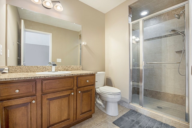 bathroom with toilet, tile patterned floors, walk in shower, and vanity