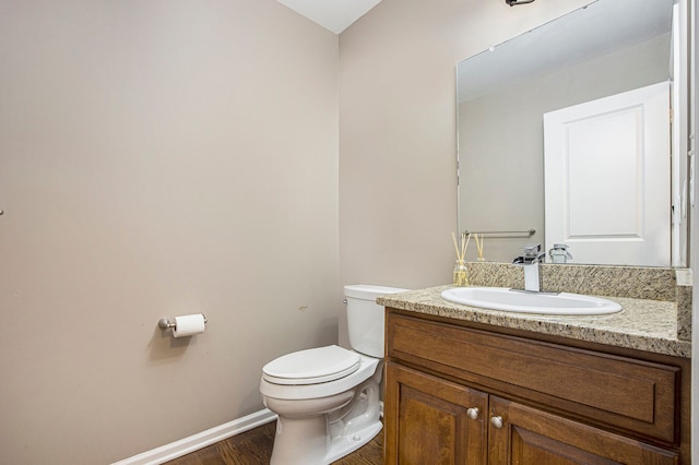 bathroom featuring toilet, wood-type flooring, and vanity