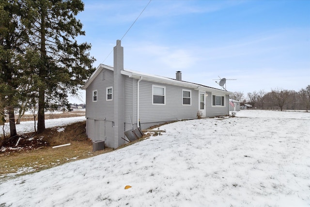 snow covered house with central AC unit